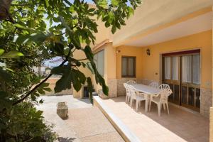 a table and chairs on the patio of a house at Casa del Sole - Grande by Salento Prime in Marina di Pescoluse