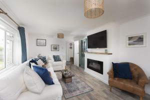 a living room with a white couch and a fireplace at Finest Retreats - Chyvounder in Sennen