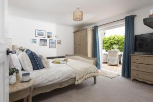 a bedroom with a bed and a tv and a window at Finest Retreats - Chyvounder in Sennen