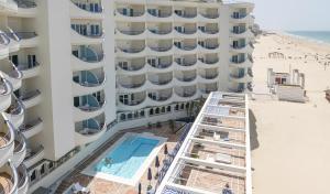 an aerial view of a hotel with a swimming pool and the beach at Hotel Playa Victoria in Cádiz