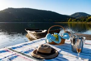 a picnic table with a basket and a hat and a glass of wine at Canto do Zêzere, Sertã, Dornes, Castelo do Bode in Cernache do Bonjardim