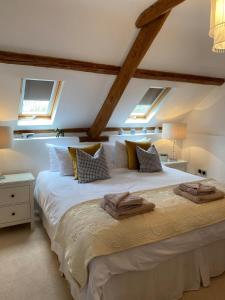 a bedroom with a large white bed with two windows at The Tall Barn in Rose Ash