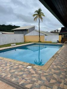a swimming pool with a palm tree in the background at Villa Joya Kourou in Kourou +36 photos