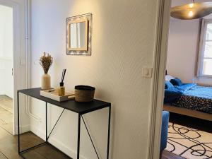 Habitación con mesa, espejo y cama. en Chez SEB, en Rodez 11 fotos más