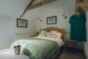 a bedroom with a bed with a green blanket at The Barrington Boar in Ilminster