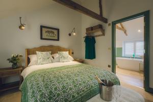 a bedroom with a bed and a tub in a room at The Barrington Boar in Ilminster