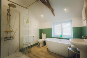 a bathroom with a tub and a sink and a toilet at The Barrington Boar in Ilminster +29 photos