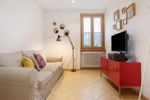 ein Wohnzimmer mit Couch und Flachbildfernseher in der Unterkunft Appartamento Pieve in Baselga di Pinè