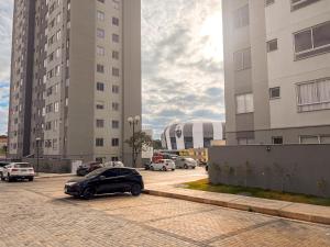 a car parked in a parking lot between two tall buildings at Apartamento alto padrão, Arena MRV, 2 quartos, garagem in Belo Horizonte