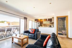 uma sala de estar com um sofá e uma mesa em Sunset T3 - by Smarthomes em São Martinho do Porto