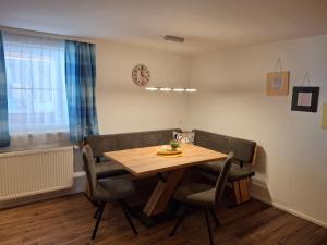 a dining room table with chairs and a clock on the wall at Daarhof in Wagrain