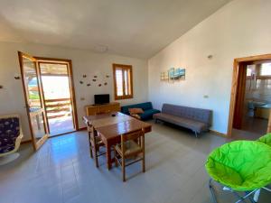 a living room with a table and a couch at Appartamento Baia Mimose in Badesi
