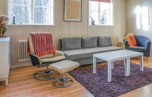 a living room with a couch and a table and chairs at 5 Bedroom Amazing Home In Kilsmo in Kilsmo