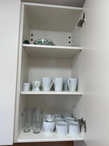 a shelf filled with white cups and vases at Litus in Njivice