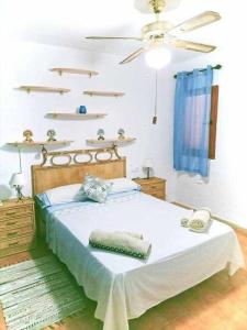 Un dormitorio con una cama y un ventilador de techo. en San José Apartamento, en San José