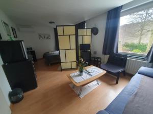ein Wohnzimmer mit einer Couch und einem Tisch in der Unterkunft BnbMarlies in Oorsbeek