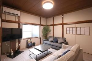 富山市にあるくつろぎのお宿 やわや 花水木のソファと薄型テレビのあるリビングルーム