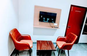 two red chairs and a table in a room at Hotel Orio Castle in Ludhiana