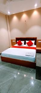 a bedroom with a large bed with red pillows at Hotel Orio Castle in Ludhiana +1 photo