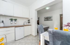 a kitchen and dining room with white cabinets at Stunning Apartment In Turanj in Turanj
