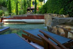a pool with a table and chairs in the water at La Fiole Ambiance in Ferrières