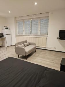 a living room with a couch and a kitchen at Appartement tout équipé in Nogent
