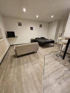 a living room with a couch and a bed at Appartement tout équipé in Nogent