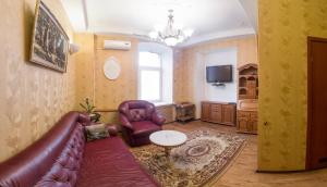 a living room with a leather couch and chairs at Gostiniy Dvor on Troitskaya in Samara