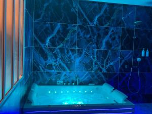 a blue tiled bathroom with a tub in a room at La Demeure d'Élodie in Épernay +46 photos