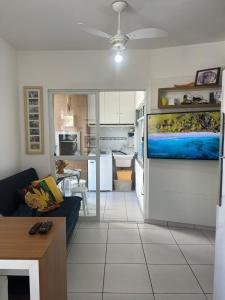 Una sala de estar con un sofá y una cocina. en Apartamento Itapema centro, en Itapema