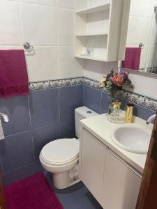 Un baño con un inodoro blanco y un lavabo. en Apartamento Itapema centro, en Itapema