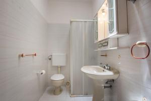 a white bathroom with a toilet and a sink at Casa del sole pp by Salento prime in Marina di Pescoluse