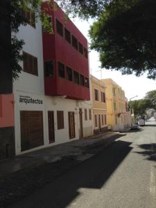 een rood-wit gebouw aan de straatkant bij Guest House Soncent in Mindelo