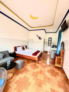 a large room with a bed and a couch at Minh Khoi Guest House in Mui Ne