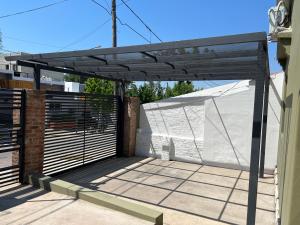 a black pergola on the side of a house at La Petrona in Alta Gracia