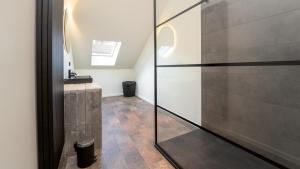 a bathroom with a glass shower stall and a sink at ZILTer - Groot duplex appartement met terras in Ostend