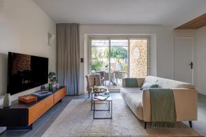 un salon avec un canapé et une télévision dans l'établissement Basti Lou - Proche du village de Gordes, à Gordes