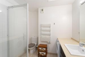 une salle de bains blanche avec toilettes et lavabo dans l'établissement Cap Vauban - Duplex à 200m de la plage, à Saint-Malo