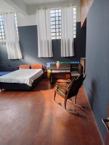 a bedroom with a bed and a chair in a room at Casa loft Internet 500Mb in Sao Paulo
