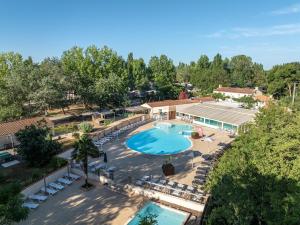 an overhead view of a large swimming pool with lounge chairs at Camping Clos Cottet in Angles