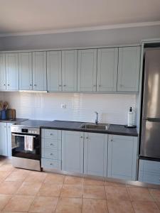 a kitchen with white cabinets and a sink at Agia Effimia RIVIERA APPARTMENT in Agia Effimia +8 photos