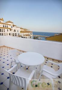 
a white chair sitting on top of a wooden floor next to a beach at Park Plaza Suites Apartamentos in Marbella
