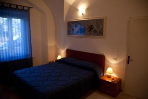 una camera con un letto blu e due luci notturne di Casa Baia del Quercetano a Castiglioncello