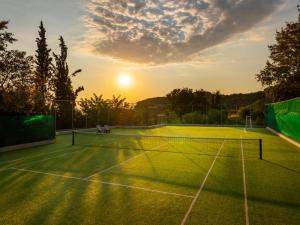 a tennis court with the sunset in the background at Mount Athos Resort in Ierissos