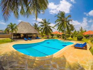 an image of a swimming pool at a resort at Doric Cottages Diani in Diani Beach