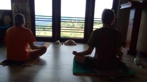 zwei Männer, die auf dem Boden sitzen und aus dem Fenster schauen in der Unterkunft Kandy Hindagala Retreat - Boutique Villa in Kandy Hills Sri Lanka in Kamburadeniya