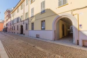 a cobblestone street with an archway and buildings at Residence Croce in Piacenza