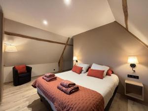 a bedroom with a large bed and a chair at Chant des mouettes Maison rénovée spacieuse tout confort grand jardin belle terrasse aménagée parking 8 personnes 4 sdb 5 wc à 10 mn à pied de la mer Port en Bessin tous commerces restaurants proche Omaha Beach in Port-en-Bessin-Huppain