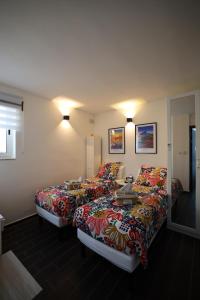 a hotel room with two beds with colorful sheets at Nemy Sliema Guesthouse in Sliema