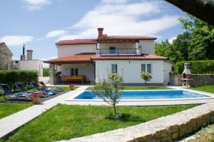 a villa with a swimming pool in front of a house at Villa Tominčići By Istrialux in Pićan